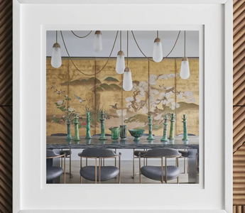 Dining table set with green glass vases and hanging pendant lights featuring statement pieces in minimalist maximalist design