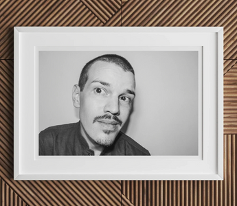 Black and white portrait of man with goatee and short hair looking directly at camera in article about childhood surrounded
