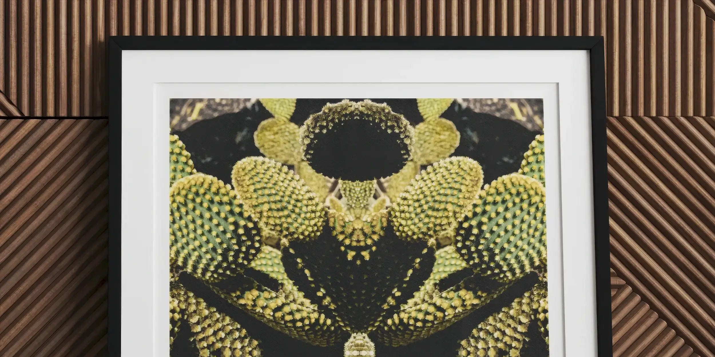 Framed abstract artwork featuring a symmetrical pattern of yellow and black shapes resembling organic forms.
