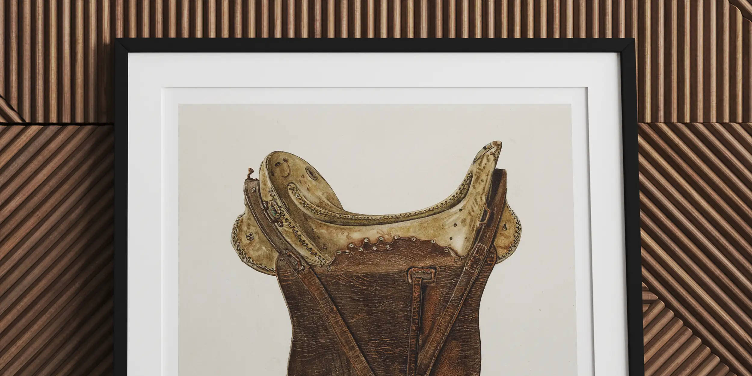 Framed artwork depicting a vintage leather horse saddle with stirrups.