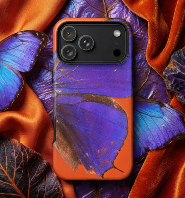 Butterfly phone cases featuring a vibrant purple butterfly against an orange background on a textured surface.