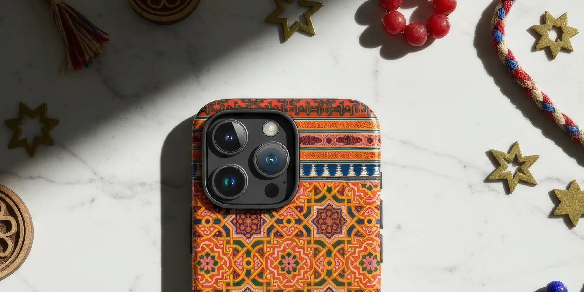 IPhone with a decorative gold and white floral patterned case.