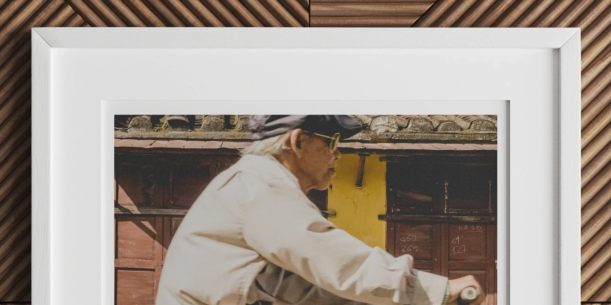 Framed photograph of an elderly person riding a bicycle.