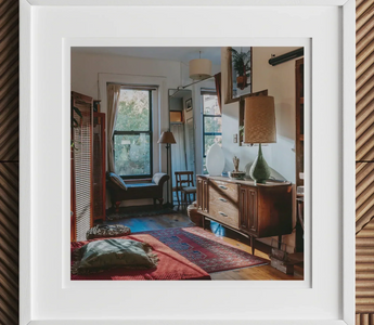 Cozy eclectic living room with vintage furniture and colorful rugs showcasing mixed patterns from early 20th centuries
