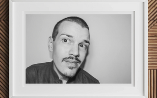 Black and white portrait of man with goatee and short hair looking directly at camera in article about childhood surrounded