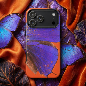 Butterfly phone cases featuring a vibrant purple butterfly against an orange background on a textured surface.
