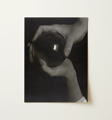 Artwork featuring hands holding a glass orb, inspired by Alfred Stieglitz's photographic vision.