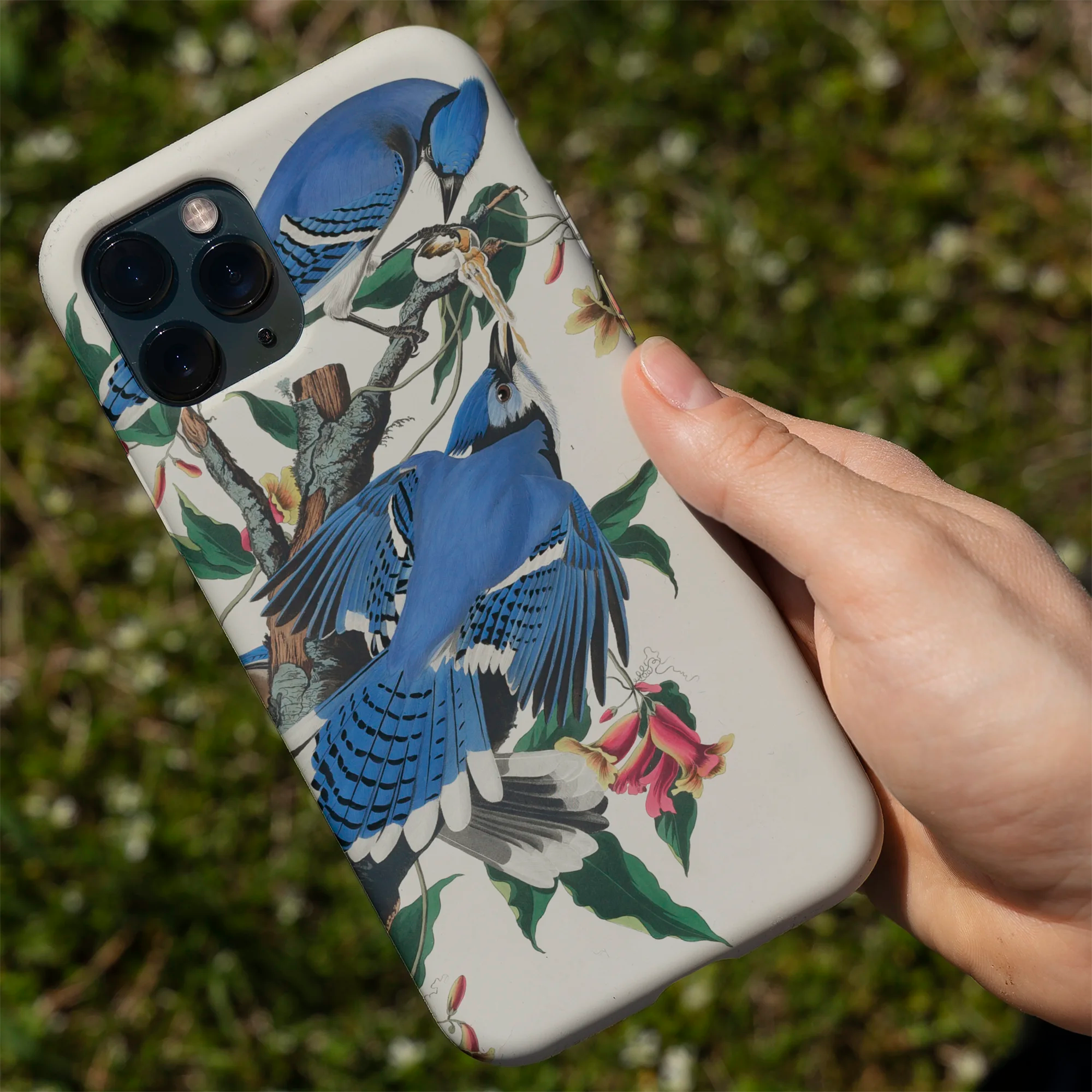 IPhone with a blue and white floral patterned case.