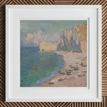 Framed painting of a coastal scene with cliffs, beach, and boats.