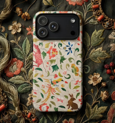 Colorful decorative phone cases set on a rich, patterned fabric background showcasing folk art elements.