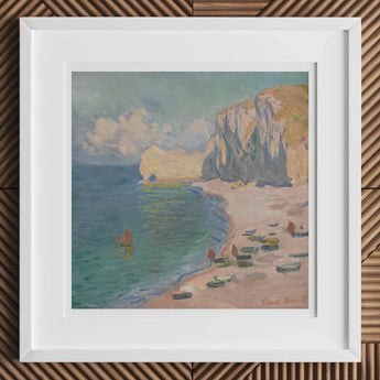 Framed painting of a coastal scene with cliffs, beach, and boats on the water.
