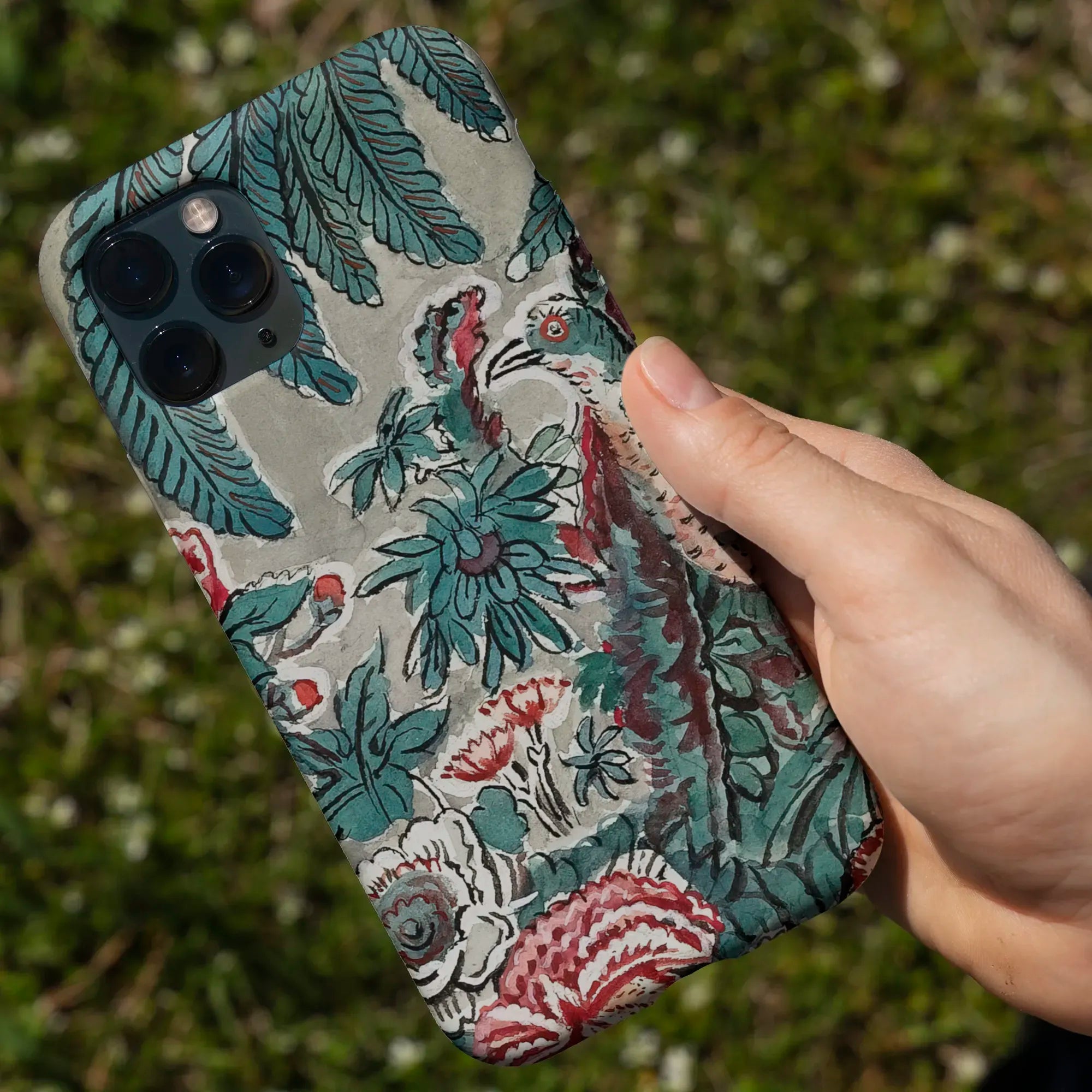 Floral-patterned phone case for an iPhone, featuring teal leaves and colorful botanical designs.