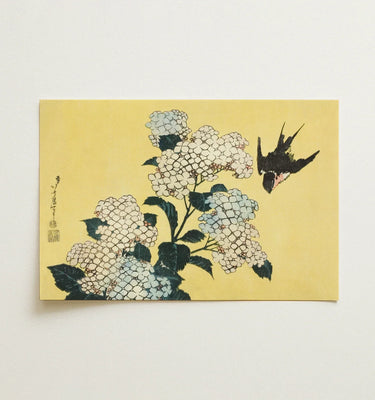 Decorative phone case with a nature-inspired artistic design held in a hand.