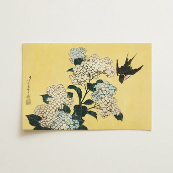 Decorative phone case with a nature-inspired artistic design held in a hand.