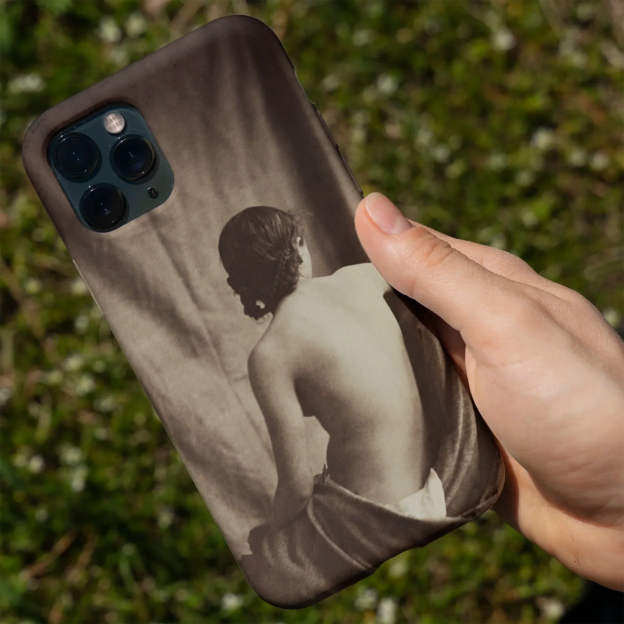 IPhone with a sepia-toned nude figure case.