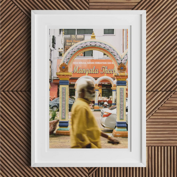 Framed photograph of a colorful archway labeled ’Mangala Street’ with a blurred figure in yellow passing by.