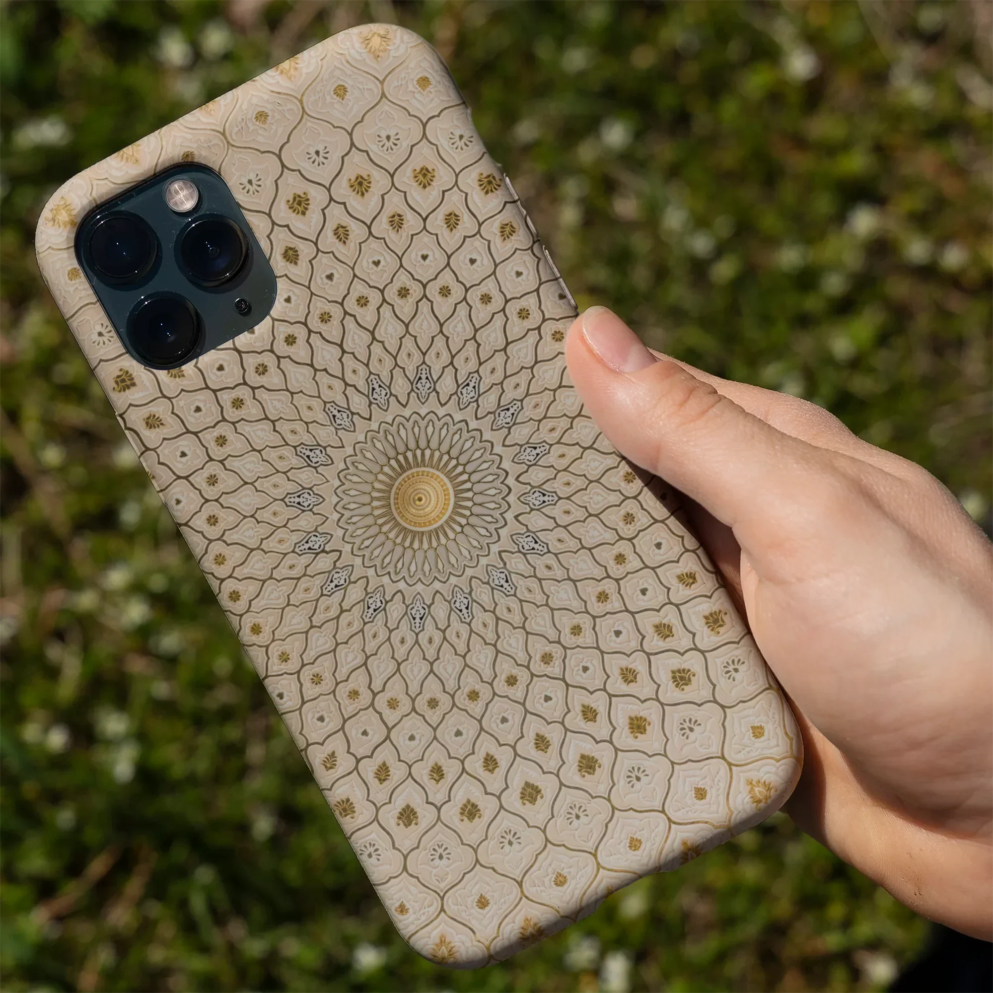 Smartphone with a decorative mandala-patterned case.
