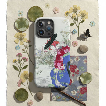 Woman in a yellow kimono with a floral pattern sitting near a stone lantern.