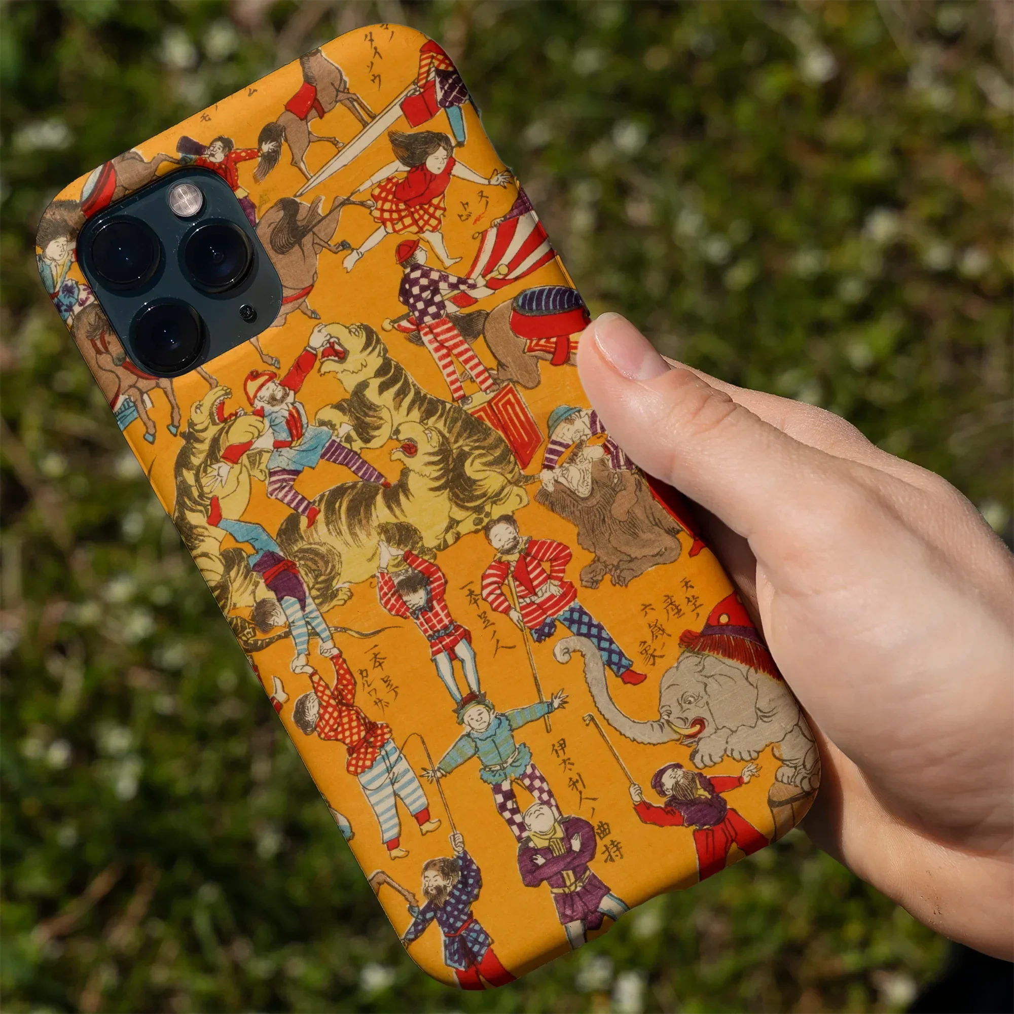 IPhone with a decorative gold and white floral patterned case.