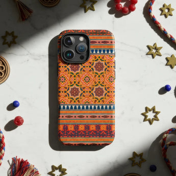 IPhone with a decorative gold and white floral patterned case.