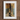 Framed painting depicting a person in traditional Middle Eastern attire standing between ornate columns.