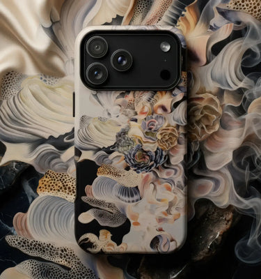 Surreal Phone Cases featuring a detailed artistic design on a mobile device surrounded by shells and succulents.