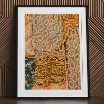 Framed artwork depicting colorful, patterned textiles with intricate designs.