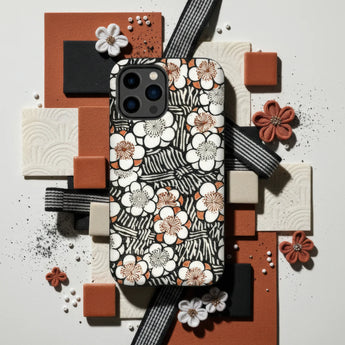 Floral patterned laptop sleeve or case with white and orange blossoms on a black and white striped background.