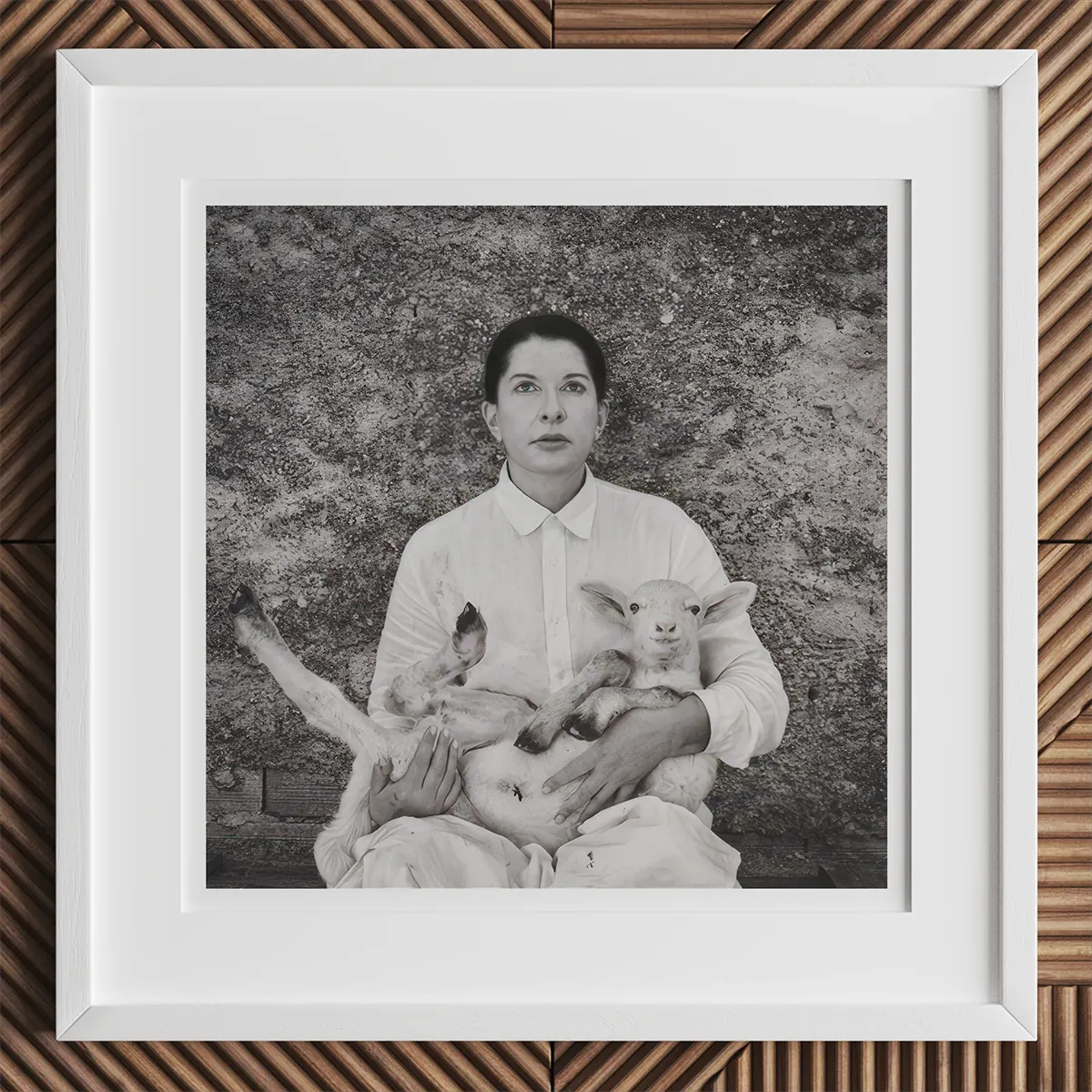 Framed black and white photo of a woman holding a lamb in an art gallery scene