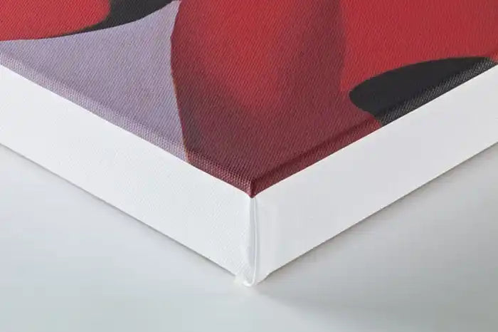 Corner of a white-framed canvas with red artwork or print.