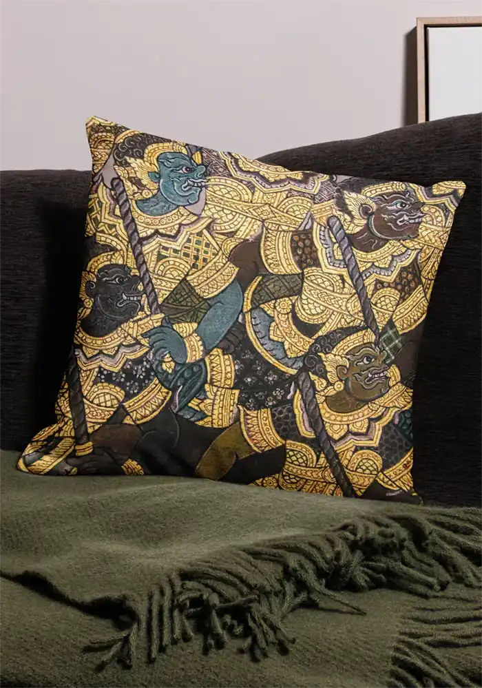 Decorative pillow with Thai-style mythological figures in gold, blue and black patterns.