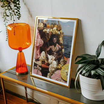 Douglas - Black Gay Pirate Art Print, Framed Photograph Alongside Orange Table Lamp Potted Plant