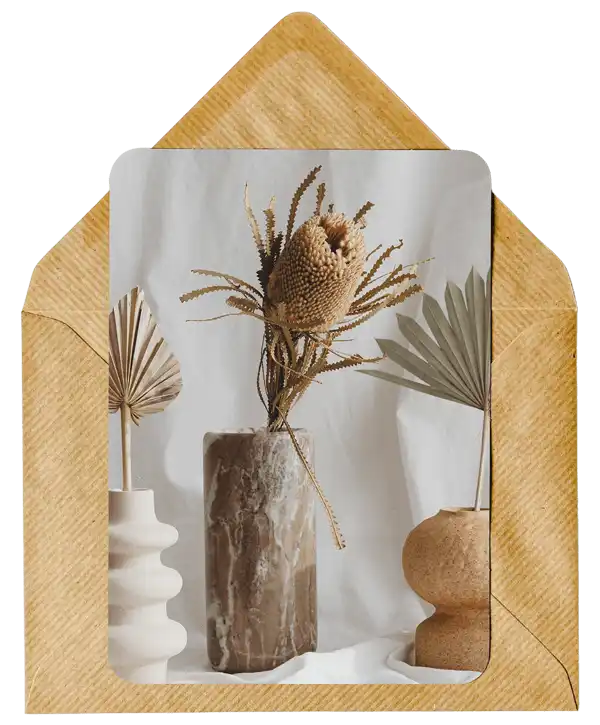 Dried botanical arrangement in a textured vase with palm fronds.