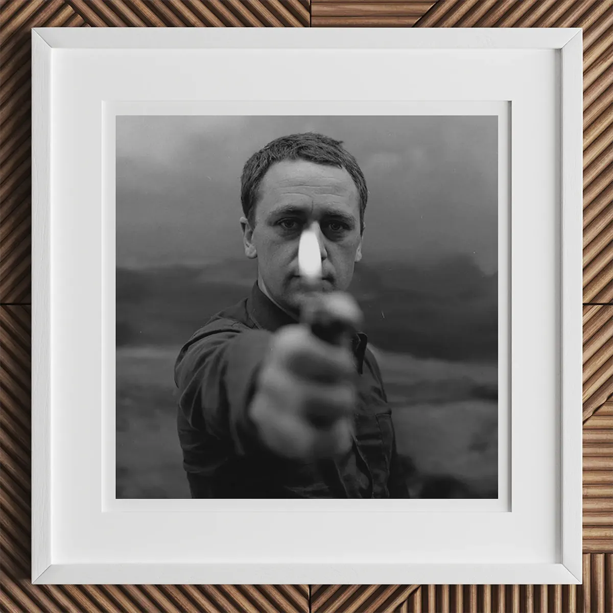 Framed black and white photo of a man pointing a gun, inspired by Andy Warhol style