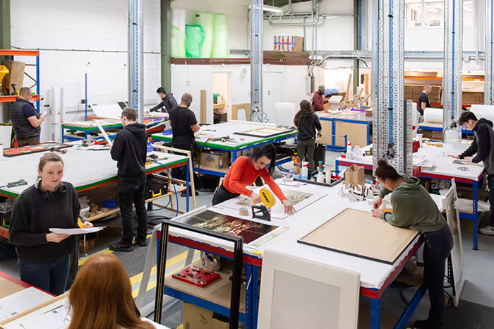 Print lab with multiple workstations where people are engaged in hands-on art print projects