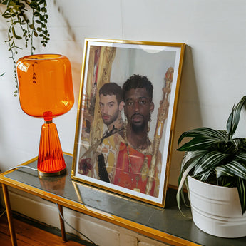 Hadrian & Antinous - Gay Interracial Couple Art Print, Framed Photograph Alongside Orange Table Lamp Potted Plant