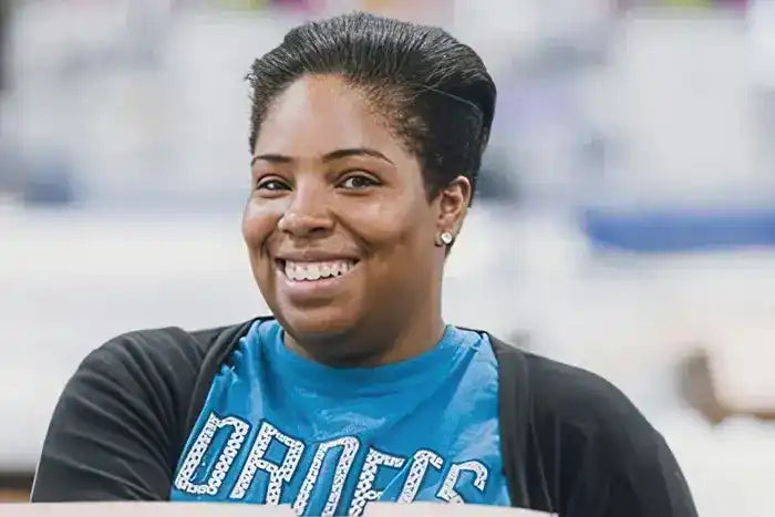 A smiling person wearing a blue ’Orders’ t-shirt.