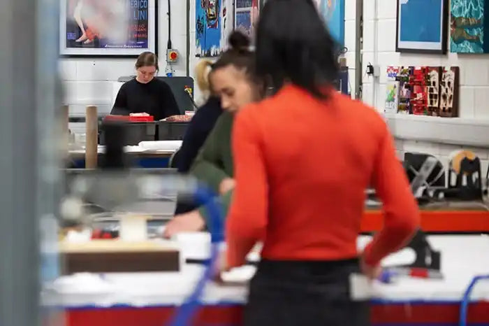 Person in a bright red sweater working at a table.