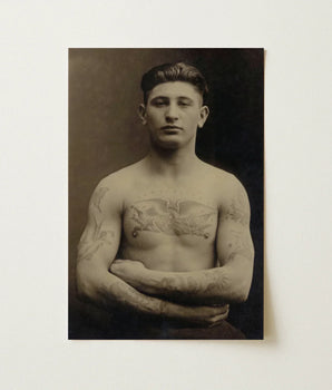 Vintage Sepia-toned Portrait Photograph Tattooed Man Arms Crossed Soldier Faces Forward, Torso Unclothed, Body Transformed